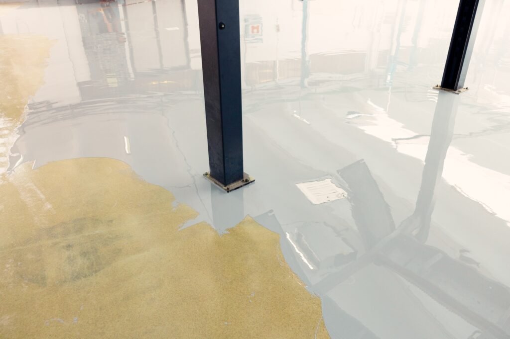 Worker applying epoxy resin in an industrial facility