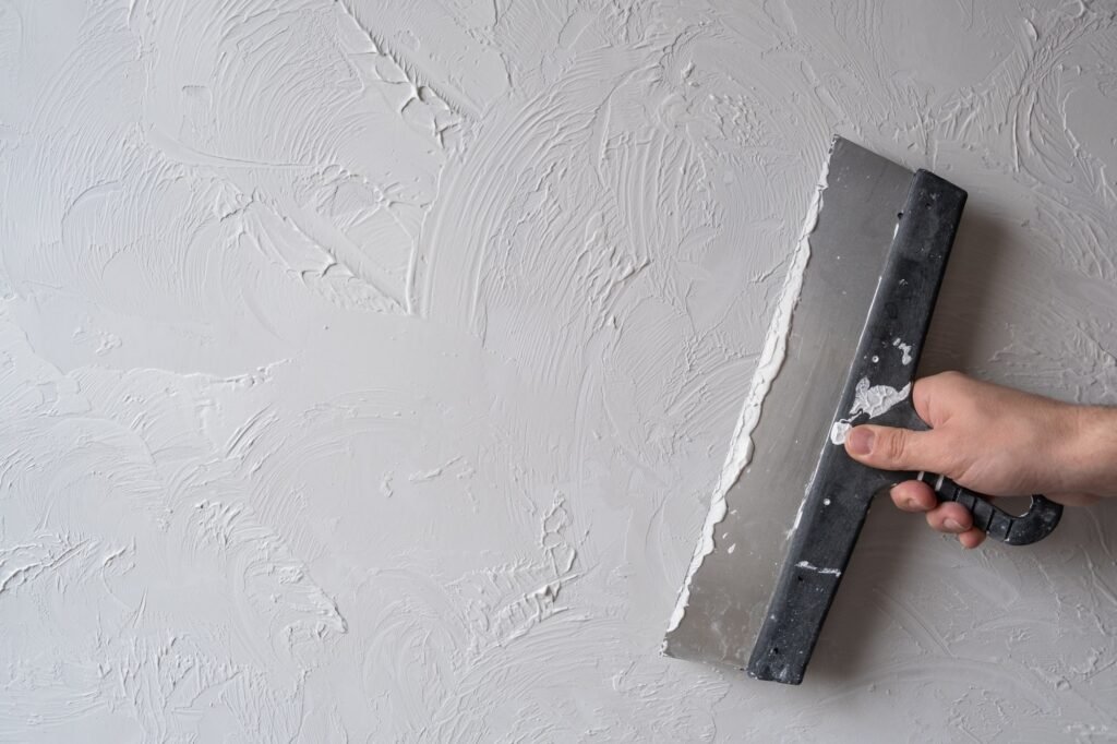 Applying decorative putty on the White abstract texture of surface