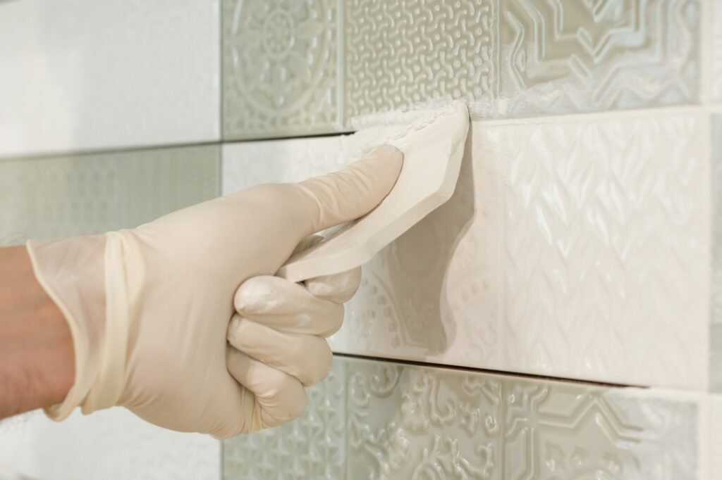 a man rubbing tile, Installing and grouting decorative finishes