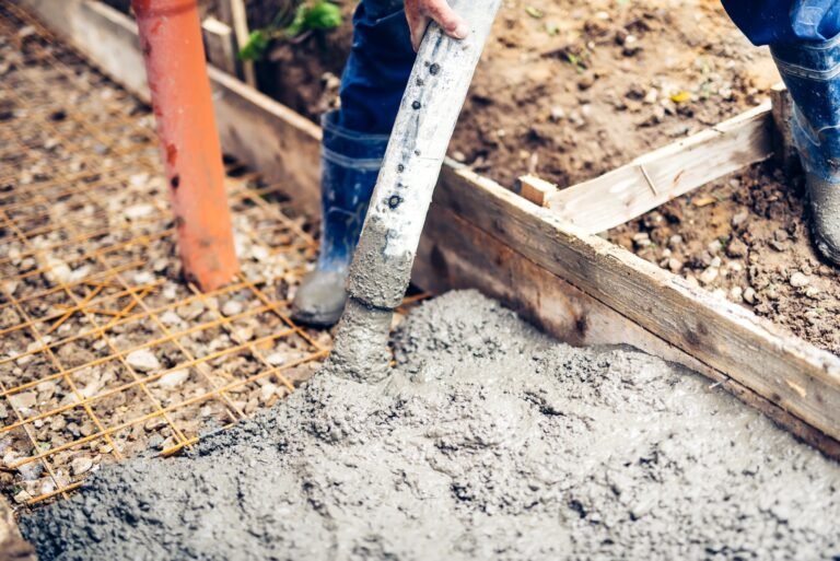 construction site - worker pouring cement and concrete with pump tube on reinforcement steel bars