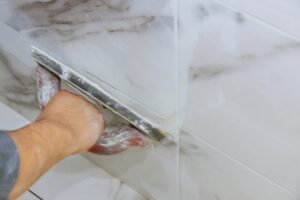 Grouting ceramic tiles using a rubber trowel