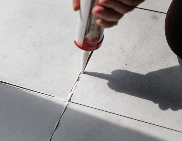 a man filling the floor white tiles gaps