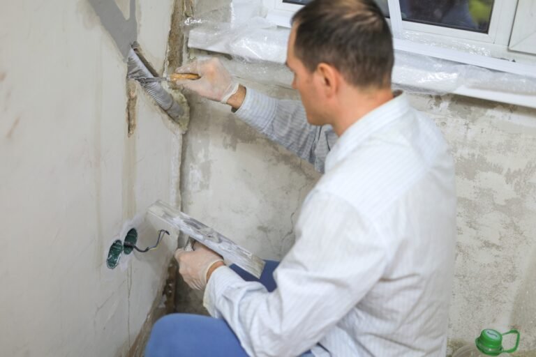 a man covers the wall with mortar with a construction tool