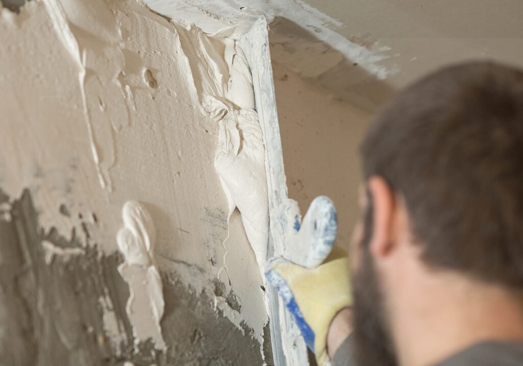 the process of smearing plaster mortar putty with a spatula on the wall