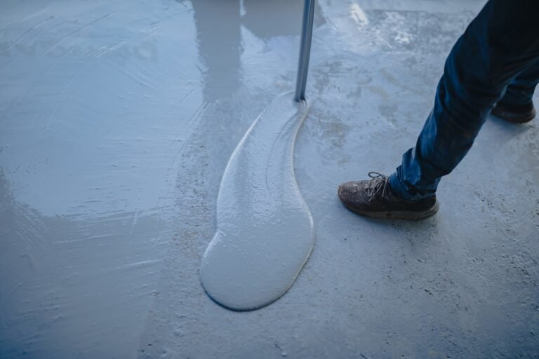 The worker applies gray epoxy resin to the new floor