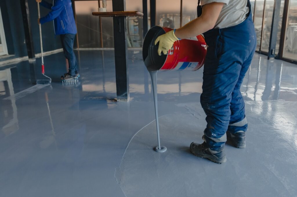 the-worker-applies-gray-epoxy-resin-to-the-new-floor