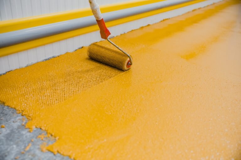 Worker applying epoxy and polyurethane flooring system