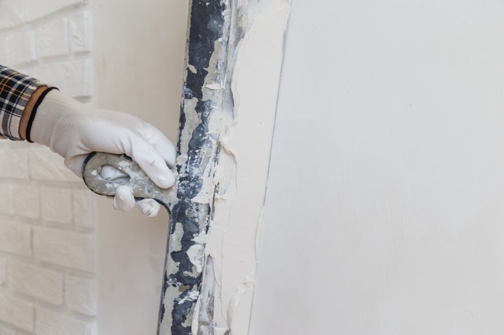 worker-in-white-gloves-performs-plastering-of-the-walls-of-the-room